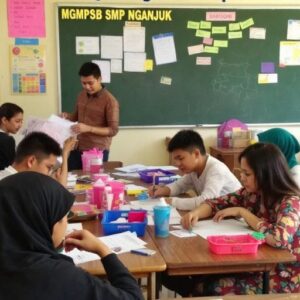 Kelas yang ceria dengan siswa berkolaborasi dan belajar.